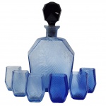 Conjunto contendo linda licoreira Art Deco, anos 50, confeccionada em vidro azul cobalto, inclui uma garrafa facetada e seis copinhos. Medida licoreira: 25cm x 16cm.