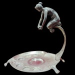 Antigo porta-copos de licor Art Nouveau, anos 50, em metal espessurado a prata. Com escultura feminina ao topo. Medida: 27cm x 25cm.