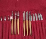 Antigo conjunto de talheres vintage para petiscos, confeccionados em inox com cabo em madeira, acompanha capa de armazenamento em veludo vermelho.