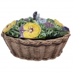 Antiga biscoiteira em cerâmica francesa, da marca Sarreguemines, datada de aproximadamente 1900-1910, base moldada como um cesto de vime e uma tampa decorada com flores de amor-perfeito em alto relevo e policromia. Medida: 30cm x 20cm x 15cm.