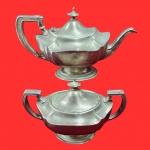 REED&BARTON - Par de pecas sendo uma leiteira e um açucareiro em metal espessurado a prata. Medida maior: 26cm x 15cm.