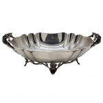 Antigo centro de mesa art nuveu, com rico design corpo gomado e bordas recortadas, alças e base cinzeladas com detalhes em folhagens e arabescos, apoiando-se sobre pés ricamente ornamentados. Em metal espessurado a prata. Medida: 30cm x 20cm x 10cm.