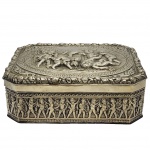 Antiga Caixa de charutos, estivlo art nuveau XX, Com decoração em relevo de figuras de querubins e motivos de folhagens na tampa e laterais, peça em metal espessurado a prata. Medida: 21cm x 14cm x 7cm.