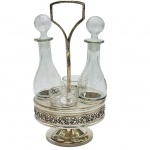 Antiga galheteira, anos 50, art deco, em cristal lapidado com suporte em metal prateado. Contendo dois galheteiros e dois porta molhos em cristal com rica lapidação de folhas e galhos. Medida total: 27cm x 17cm.