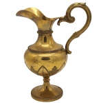 Antiga Gomil / Jarra em metal dourado, com ricos detalhes gravados na base e uma alça ornamentada, confeccionda em metal dourado. Medida: 23cm x 18cm.