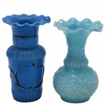 OPALINA - Dois vasos de flor solitária, confeccionados em peça única de opalina no tom azul, com ricos detalhes em caneluras em relevos e bordas recortadas. Medida: 12cm x 8cm.