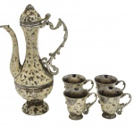 Antigo Conjunto de chá Turco, composto por um bule (ou jarra) e quatro xícaras, confeccionados em metal decorado no tom branco em relevos com pega lateral ornamentada. Medida bule: 20cm. Obs, apresenta marcas do tempo.