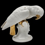 COLECIONISMO - Estatueta representando "Pássaro" em porcelana branca e vitrificada, decorada em frisos de ouro no bico, nas garras e na cauda. Medida: 20cm x 17cm.