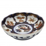 PORCELANA - Antiga tigela, em porcelana Oriental estilo Imari do século XIX, decorado em padrões intrincados de cartuchos florais e paisagísticos sobre um fundo azul escuro com detalhes em treliça dourada. Medida: 15cm x 4cm.