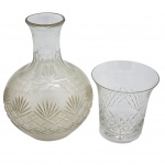 CRISTAL - Conjunto contendo antiga garrafa e copo anos 50, confeccionada em cristal com lapidação em palmas e geométricos. Medida total: 20cm.