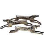Delicado conjunto contendo três Apoiador de colheres, em metal espessurado a prata, em formato de cachorro. Medida: 10cm. Obs: no estado.