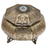 Antiga Caixa porta-joias em metal prateado, decorada com arabescos e pequenas incrustações em porcelana com motivo floral. Em metal espessurado a prata. Medidas: 16 cm x 12 cm.