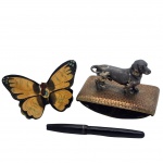COLECIONISMO - Antigo Mata-borrão em metal dourado e prateado, decorado com escultura de cachorro salsicha. Acompanha caneta em estilo antigo e decoração de parede de borboleta em madeira Obs. no estado.
