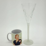 Conjunto composto por duas peças: uma taça em cristal com rica lapidação representando cavalo e uma xícara com "Evita" . Medida da taça: 30 cm.