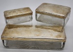 Conjunto de molheiras em cristal lapidado, formato retangular, com tampas em metal espessurado a prata. Medidas: maior 23 cm x 5 cm x 8 cm; menor 11 cm x 5 cm.