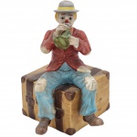 COLECIONISMO - Estatueta de Palhaço tocando corneta em porcelana vitrificada, em rica policromia. Medida: 18cm x 10cm.