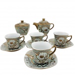 PORCELANA -  Parte de conjunto composto por quatro xícaras de chá com seus pires, um açucareiro e uma leiteira. Decorado em padrão floral com frisos de ouro.
