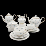 TUSCAN ENGLAND - Porcelana England, anos 1950  Parte de conjunto em fina porcelana, ricamente decorada em padrão vegetalista azul. Composto por: par de xícaras de chá com seus pires, par de pratos de sobremesa, uma queijeira, dois bules (café e chá) e uma leiteira. Observação: uma xícara e a queijeira apresentam fio de cabelo.