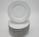 Conjunto de 12 pratos de sobremesa em porcelana, decorados com frisos prateados e delicados motivos florais em tom branco.