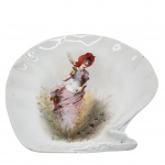 PORCELANA - Petisqueira em porcelana, em formato de concha, com rica decoração feita a mão representando figura feminina campestre. Medidas: 32 cm x 30 cm. Obs. apresenta fio de cabelo.