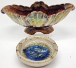 Conjunto de duas peças decorativas: uma floreira em formato de concha, no tom marrom, e um cinzeiro com centro azul.