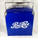 COOLER azul adesivado da PEPSI-COLA, para armazenamento de latinhas de refrigerantes, cervejas, etc... Sem uso. Possui abridor de garrafas na lateral e a Alça se move para abrir a tampa. Mede sem a alça aprox. 30 x 30 x 23 centímetros.