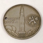 MEDALHA PROJETO APOLLO XVII (17). Apresenta um furo junto a letra `P` de PROJECT. Mede aprox. 3,9 cm de diâmetro. A missão Apollo 17 (07 a 19 de dezembro de 1972) foi a sétima e última do programa Apollo. Com exceção da Apollo13, que foi vítima de uma explosão que impediu seu pouso na Lua, todas as outras 6 missões foram cumpridas com êxito. A tripulação da Apollo 17 foi composta por Eugene Cernam, Ronald Evans e Harrison Schmitt.