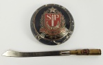 CONDE GUILHERME PRATES - CONJUNTO PARA ESCRITÓRIO COMPOSTO POR  PESO DE PAPEL EM MÁRMORE NERO PORTORO COM EMBLEMA EM METAL CONTENDO ENCASTOADO O BRASÃO DE SÃO PAULO DURANTE A REVOLUÇÃO DE 1932 .  UM ESCUDO VERMELHO E UMA ESPADA COM O PUNHO VOLTADO PARA BAIXO SOBRE O CRUZAMENTO DE UM RAMO DE LOURO, À DIREITA E UM RAMO DE CARVALHO, À ESQUERDA. A LÂMINA SEPARA AS LETRAS "SP". O TIMBRE É UMA ESTRELA EM PRATA. O SUPORTE SÃO DOIS RAMOS DE CAFEEIRO FRUTIFICADOS (A RIQUEZA PAULISTA). PRO SAO PAULO FIANT EXIMIA (POR SÃO PAULO FAÇAM-SE GRANDE COISAS). TAMBÉM UMA ESPÁTULA PARA CARTAS COM PEGA FEITA POR UMA BALA DE FUZIL REMATADA PELO BRASÃO DE SÃO PAULO. DEC. 30. 8,5 CM DE DIAMETRO (PESO DE PAPEL)