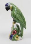 BORDALLO PINHEIRO  -  GRANDE ESCULTURA EM PORCELANA POLICROMADA REPRESENTANDO FIGURA DE PAPAGAIO ASSENTE SOBRE PULEIRO ENFEITADO COM FLORES E RAMAGENS.  PORTUGAL, SEC. XX. 28 CM DE ALTURA