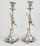 SUNTUOSO PAR DE GRANDES CASTIÇAIS EM PRATA DE LEI COM MARCAS PARA CIDADE DO PORTO (P COROADO) E PRATEIRO CLASSIFICADO POR MOITINHO COMO P58 DATAVEL ENTRE 1870 E 1881. DECORAÇÃO FIGURATIVA COM FUSTE NO FEITIO DE DANÇARINA USANDO JÓIAS, COM CABELOS ARTISTICAMENTE ARRANJADOS E SENSUAIS TRAJES DE DANÇA. A BASE TEM MAGNIFICOS GUILLOCHES. PÉS COM FEITIO DE FOLHAS. PORTUGAL, DEC. 1870. 32 CM DE ALTURA