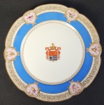 BARÃO DE SÃO FIDELIS  ANTONIO JOAQUIM DA SILVA PINTO (1826-1884) LINDO PRATO EM PORCELANA COM MARCAS DO ATTELIER DE CHARLES PILIVUYT MEDAILLE DOR EXPOSITION UNIVERSELLE 1867. BORDA COM FEITIO RECORTADO FILETADA EM OURO E SUCEDIDA POR INTRICADA GREGA EM OUROINTERROMPIDA POR RESERVAS COM FEITIO DE CORAÇÃO CONTENDO FLORES E PÁSSAROS. DELIMITANDO A CALDEIRA GROSSO BARRADO EM AZUL POMPADOUR. A CALDEIRA TEM GREGA EM OURO EMOLDURANDO BRASÃO CENTRAL COROADO COM AS ARMAS DE  ANTONIO JOAQUIM DA SILVA PINTO (1826-1884), BARÃO DE SÃO FIDELIS.  PAQUIFES EM OURO GUARNECEM O BRASÃO. BRASÃO DE ARMAS DATADO DE 25.05.1868. REGISTRADO NO CARTÓRIO DA NOBREZA, LIVRO VI, FLS. 99: ESCUDO ESQUARTELADO: NO 1.º, EM CAMPO DE GOLES, 5 CRESCENTES DE LUA DE OURO, POSTOS EM ASPA; NO 2.º, DE GOLES, 2 CANAS DE AÇÚCAR DE OURO, POSTAS EM SANTOR; NO 3.º, DE PRATA, UM LEÃO ROMPENTE DE GOLES, ARMADO DE AZUL; E NO 4.º, FAIXADO DE 6 PEÇAS DE OURO E AZUL. COROA DE BARÃO. TIMBRE: UM LEÃO DE PRATA COM UM CRESCENTE DE LUA NA ESPÁDUA ESQUERDA .EXEMPLAR DESSE SERVIÇO ESTÁ REPRODUZIDO NA PAGINAS 322 DO LIVRO LOUÇA DA ARISTOCRACIA NO BRASIL POR GENY DREYFFUS. FRANÇA, SEGUNDA METADE DO SEC. XIX. 23,5 CMNOTA: No ano de 1867, no dia 10 de julho, lembrando São Fidélis, o Imperador, objetivando premiar o cidadão Antonio Joaquim da Silva Pinto, pelos relevantes e patrióticos serviços prestados durante a Guerra do Paraguai, o agraciou com o título de barão de São Fidélis e ainda com a comenda da Ordem de Rosa. O barão de São Fidélis, descendente de ilustre família portuguesa, nasceu na cidade de Campos, na Freguesia de São Sebastião, sendo seus pais Manoel Joaquim da Silva Pinto e d. Luiza Maria Pinto. Quando recebeu o título já era e já era  Cavalheiro da Ordem de Cristol. O Barão  de São Fidélis faleceu no dia 20 de setembro de 1884, na fazenda de sua propriedade, denominada Tahy, sendo seu corpo sepultado no cemitério de Carmo, na cidade de Campos.