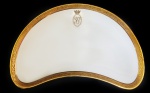 BARÃO SMITH DE  VASCONCELOS -  JAIME SMITH DE VASCONCELOS. COVILHETE EM PORCELANA COM BORDA DECORADA EM OURO RELEVADO. RESERVA OVAL APRESENTANDO O MONOGRAMA SV SOB COROA DE BARÃO NO REVERSO MARCA DE LIMOGES. FEITIO RINIFORME. OS BARÕES DE VASCONCELOS ERAM OS PROPRIETÁRIOS DO PALÁCIO DE ITAIPAVA. UMA CURIOSIDADE SOBRE OS BARÕES DE VASCONCELOS É QUE DELES DESCENDE A POLÍTICA MARTA SUPLICY. FRANÇA, SEC. XIX. 22 CM DE COMPRIMENTO.NOTA: Foi construído na primeira metade do século XX, por volta de 1922-24, pelo aristocrata anglo-brasileiro Rodolfo Smith de Vasconcellos, no bairro de Itaipava na cidade de Petrópolis. É uma reprodução de um castelo europeu. Foi projetado pelo arquiteto Fernando Valentim (Lúcio Costa creditava a responsabilidade pelo projeto totalmente ao seu antigo sócio).A construção foi realizada por vinte famílias trazidas da Europa, com material totalmente europeu: de Portugal, vieram os blocos de pedras que foram talhadas por artesãos portugueses; da França, o telhado de ardósia; da Itália, o mármore de Carrara, que compõe o piso de vários salões, inclusive o do famoso Salão do Zodíaco. As portas e janelas são de jacarandá, com ferragens inglesas; os vitrais são austríacos e, finalizando os principais detalhes, cada porta dos quartos de seus filhos tinha seus nomes gravados em ouro.Esta construção levou em torno de cinco anos. São 42 cômodos distribuídos em dezenove quartos, sete banheiros, diversos salões, bibliotecas, sala de música, halls, duas torres, diversos terraços, dependências para hóspedes, ala dos serviçais e galerias que abrigam interessantes histórias que permeiam a vida dos Smith de Vasconcellos no Brasil. O hall com as escadarias e o teto de jacarandá é finamente trabalhado. Há vitrais com as armas da família, biblioteca com estantes esculpidas em relevo, livros raros e um vasto parque cercando a mansão.Jaime Smith de Vasconcellos, o terceiro barão de Vasconcellos, na primeira metade do século XX, encomendou à fábrica inglesa Rolls Royce uma limusine com onze lugares onde passou a acomodar seus sete filhos, a baronesa Anna Teresa Siciliano (filha do conde Alessandro Siciliano, a babá e o motorista. Esse automóvel tão especial também tinha, em suas portas, gravado em ouro, o brasão de armas da família. O castelo mantém, ainda, uma torre onde está uma cópia do batistério da Catedral de São Pedro.Personalidades como Adhemar de Barros, Getúlio Vargas, Amaral Peixoto e várias pessoas das sociedades carioca e paulista frequentavam o local.