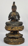 BUDDHA EM MADEIRA, PROVAVELMENTE DE SÂNDALO OU QIENANN EM POSIÇÃO DHYANASANA (POSIÇÃO DE MEDITAÇÃO). GRANDE ESCULTURA COM BUDDHA  EXECUTANDO O MUDRA DO ENSINAMENTO E SEGURANDO BOTÃO DE LÓTUS. BUDDHA É REPRESENTADO SENTADO SOBRE FLORE DE LOTUS. A ESCULTURA APRESENTA AINDA RESQUÍCIOS DA DOURAÇÃO. BELÍSSIMA! CHINA, REINADO QIANLONG, SEC. XVIII. 36 CM DE ALTURANOTA: A escultura em madeira  dourada tem mais de 1000 anos de história e está listada entre as heranças culturais intangíveis chinesas de primeiro nível. Foi inicialmente amplamente utilizado em templos, depois gradualmente aplicado aos objetos de uso diário das pessoas.   As escavações arqueológicas mostram que as técnicas essenciais de escultura em madeira estavam praticamente completas na época anterior à dinastia Qin (221207 aC). O entalhe em, em relevo atingiu um estado altamente desenvolvido. E em móveis, as habilidades de escultura em madeira entraram em ação. Edifícios de estruturas de madeira tradicionais eram outra  oportunidade para os entalhadores exercerem plenamente seus talentos; assim surgiu a frase popular, ou quase clichê, para descrever edifícios altamente decorados como diaoliang huadong, vigas esculpidas e pilares pintados, para luxo extremo e elaborado).       Além de móveis e edifícios, as habilidades de escultura também são exibidas em esculturas de figuras religiosas em madeira. O budismo prosperou durante as Seis Dinastias (220589) e os subsequentes períodos Sui (581618) e Tang (618907); havia atividades robustas na escultura de estátuas de madeira. As obras da época podem ser encontradas e vistas hoje. Quanto às estátuas de madeira feitas em North Song (960-1126), do que conseguiu sobreviver, as do Bodhisattva Guanyin em várias posturas são as mais admiradas. Eles estão sentados em postura de lótus, ou realizando abhaya mudra, ou em pé, ou em meditação, todos com postura graciosa e adequada e compostura serena, uma verdadeira declaração representativa das maravilhas da arte de escultura em madeira altamente habilidosa. no momento. A dinastia Yuan (1271-1368) deu um valor muito alto aos Cem Ofícios. Os artesãos de excelente acabamento receberam o título respeitoso de Maestro Artesão. A possibilidade do  registro de artesãos permitiu que as habilidades de escultura passassem de pai para filho por gerações, até a Dinastia Ming (1368-1644). A escultura em madeira como ofício, no entanto, ainda pertencia a outras profissões, como arquitetura, móveis e fabricação de estátuas religiosas. Depois de meados de Ming, as artes da escultura tornaram-se uma categoria artesanal independente por direito próprio. No entanto, muitos artistas de escultura, embora famosos por um único ofício, nunca se limitaram a esse único meio durante sua vida. Por exemplo, os renomados escultores de bambu Zhu Ying e Pu Cheng também esculpiram em madeira. O especialista em chifres de rinoceronte Bao Tiancheng também fez sua arte em marfim e sândalo vermelho. Na Dinastia Qing (1644-1911), havia uma oficina de marcenaria, até mesmo uma especificamente chamada de oficina de carpintaria de Cantão, instalado nas Oficinas do Departamento da Casa Imperial. Os talentosos escultores, no entanto, dedicavam a maior parte do tempo à escultura em marfim, com a escultura em madeira apenas como um trabalho secundário. Era o mesmo fora do palácio; nenhum artesão podia se dar ao luxo de esculpir madeira apenas como arte ou ofício. Tinha que fazer parte da fabricação de móveis ou da construção de estruturas com estrutura de madeira ou, na melhor das hipóteses, executada na renderização de estátuas religiosas.    Madeira de grão fino é o pré-requisito para uma escultura fina bem-sucedida. Após o polimento, deve apresentar-se fino ao tato, ou seja, liso e macio. O material ideal é o buxo. Além disso, a madeira de incenso Qienan e o sândalo são conhecidos por seu aroma agradável, enquanto o apelo do ébano está em seus tons e brilho. A madeira retorcida recebe o nome de seus muitos nós, protuberâncias e emaranhados. Os artesãos de escultura em madeira aproveitaram essa interessante forma natural e a transformaram sutilmente em obras de arte originais, com trabalho de faca mínimo e invisível.