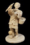 GRANDE OKIMONO EM MARFIM REPRESENTANDO VENDEDOR AMBULANTE DE FRUTOS. O COMERCIANTE CARREGA GRANDE CESTA REPLETA COM DIFERENTES FRUTOS E DEMONSTRA EM  SUAS MÃOS O PRODUTO. ASSINADO SOB A BASE. JAPÃO, SEC. XIX. 18  CM DE ALTURA