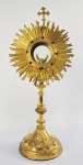 LINDO OSTENSÓRIO EM METAL DOURADO COM CRAVAÇÃO DE PEDRARIAS. (PERIODO DO CONDE EDUARDE PRATES QUANDO DA REMODELAÇÃO DA CAPELA)  BASE EM ESTILO NEO GOTICO POSSUI REPRESENTAÇÃO DOS QUATRO EVANGELISTAS (O TOURO, A ÁGUIA, O LEÃO E O ANJO) EM MAGNIFICA ESTADO DE CONSERVAÇÃO. FRANÇA, FINAL DO SEC. XIX. 48 CM DE ALTURA. NOTA: Em 1897, Francisco Tommaso Ferrara assumiu as obras para o engrandecimento da Capela, transformada em Igreja vinculada por outorga Papal a Basílica de São João Laterano de Roma, com os mesmos privilégios e indulgências concedidas por S.S. o Papa Leão XIII. Suas arcadas das portas e janelas, altar mor e torre tem caraterísticas arquitetônicas goticisantes.   . No frontispício das grandes portas de entrada  projeta-se um enorme coronel de Conde sobre as inicias EP (Eduardo Prates) entrelaçadas (marca de pertença do Conde de Prates utilizada desde a obtenção do título nobiliárquico papal). O interior do templo é magnificamente guarnecido com vitrais de CONRADO SORGENICHT e pinturas decorativas com marmorizados também produzidas por esse brilhante artista. Finalmente o teto foi magnificamente decorado pelo pintor ANTÔNIO FERRIGNO (1863-1940). Na Fazenda Santa Gertrudes, desde o início os padres que a serviram, pertenciam às ordens religiosas italianas: Scalabrinos e posteriormente Stigmatinos. Como em toda a zona da cafeicultura, o sacerdote não residia na Fazenda, mas sua presença era constante. Ao contrário do que era comum, aqui suas funções eram ambivalentes, de um lado, cuidava de assegurar a assistência espiritual dos trabalhadores católicos, e em sua maioria imigrantes italianos, o que era totalmente exequível, em virtude da identidade de origem. Imaginemos o quanto era importante para o imigrante italiano trabalhar numa Fazenda cuja Capela lhe dava as mesmas regalias das grandes Igrejas da terra natal e ainda ser atendido espiritualmente por padres de sua nacionalidade. De outra parte, o patrão, Conde Papal, na medida em que era atendido por padres vindos diretamente da Itália, estava sendo atendido à altura de seu status. Porém, o mais importante era que ao cuidar do trabalhador, em especial italiano, o sacerdote servia como um elemento tendente a garantir a fixação desse trabalhador na fazenda.