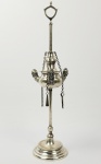 ANTIGA LAMPADA DE AZEITE EM PRATA DE LEI. DOTADA DE TRÊS LUMES DECORADOS COM PERSONAGENS ANTROPOMÓRFICOS. CORRENTES PRESAS AO CORPO SUSTENTAM ATIÇADOR, APAGADOR E PINÇA. BELA E RARA PEÇA. BRASIL, SEC. XIX. 36 CM DE ALTURA. 340 G