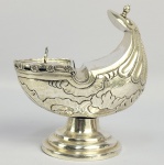 NAVETA EM PRATA DE LEI BATIDA CINZELADA E REPUXADA. DECORADA EM ROCAILLE. ELEGANTE FEITIO CONCHEADO. BRASIL, SEC. XVIII/XIX. 13 CM DE ALTURA