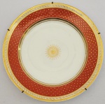 DOM JOÃO VI SERVIÇO PINGO DE OURO BELO PRATO EM PORCELA COM MARCAS DO ATELIER DO DECORADOR DEROCHE. CONHECIDO COMO SERVIÇO PINGO DE OURO. ABA COM BORDA CONTENDO FRISO DOURADO QUE DELIMITA FAIXA EM BRANCO REMATADA EM OURO. SEGUINDO EM DIREÇÃO A CALDEIRA LARGA FAIXA EM ROUGE DE FEUR PONTILHADAS EM OURO. NO CENTRO DA CALDEIRA ROSÁCEA TAMBEM EM OURO. REPRODUZIDO NA PAGINA 179 DO LIVRO "LOUÇA DA ARISTOCRACIA NO BRASIL" POR JENNY DREYFUS. FRANÇA, CIRCA DE 1813. 22 CM DE DIAMETRO