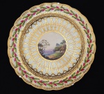 DOM JOÃO VI - SERVIÇO DE DERBY RICO - PRATO EM PORCELANA DE DERBY DITO !DERBY RICO"  DO PERÍODO DUESBURY EM PASTA MOLE. CERCA DE 1790. SUNTUOSA DECORAÇÃO EM OURO FORMANDO GUIRLANDAS ELIPTICAS. ABA TEM RICA GUIRLANDA VEGETALISTA EM ESMALTES VERDES E ROSA. RESERVA COM CENA LACUSTRE MOSTRANDO PERSONGENS, VEGETAÇÃO E PÓVOA. REPRODUZIDO NA PAG. 185 DO LIVRO LOUÇA DA ARISTOCRACIA NO BRASIL POR JENNY DREYFFUS. INGLATERRA, FINAL DO SEC. XVIII. 22,5 CM DE DIAMETRO