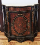 MARQUÊS DE TRÊS RIOS - JOAQUIM EGYDIO DE SOUZA ARANHA - PALACIANA DUNKERQUE ESTILO BOULLE EM MADEIRA COM GUARNIÇÃO EM BRONZE ORMOLU E INCRUSTRAÇÃO DE TARTARUGA NATURAL. FEITIO ABAULADO. PORTA CENTRAL COM FIGURA DITA SOLEIL, UMA CARIATIDE IRRADIANDO RAIOS SOLARES. TAMBEM ROBUSTAS CARIATIDES NAS LATERAIS EM MAGNIFICO BRONZE CINZELADO. PEÇA MAGNIFICA! FRANÇA., CIRCA DE 1880.  105 X 110 X 50 CMNOTA: André-Charles Boulle (Paris, 11 de Novembro de 1642  Paris, 29 de Fevereiro de 17321), desenhou e produziu mobiliário para a corte de Luís XIV como mestre de ebanisteria (marcenaria fina), ficando principalmente famoso pelo seu trabalho de marqueteria de alta qualidade (mosaico ornamental composto por diferentes materiais).A inovação introduzida nesta técnica, já anteriormente existente, é a utilização de novos materiais em combinação com uma perfeita execução da técnica. As peças de Boulle, além de utilitárias, são verdadeiras peças de joalharia, não só pelo detalhe e requinte dos padrões decorativos, como também pela utilização de valiosos materiais. O estilo das suas peças de mobiliário, formalmente dentro do estilo decorativo Luís XIV (Barroco), influenciou a estética por toda a Europa, dando nome ao que ficou conhecido como o estilo boulle (também marquetaria boulle ou técnica boulle). O mobiliário criado por Boulle tem uma estrutura base simples, de linhas bem definidas, sobre a qual são depois aplicadas as peças da marqueteria. Os materiais de eleição são materiais que ofereçam um bom contraste de cor e efeito visual claro-escuro. As aplicações metálicas (latão ou bronze, geralmente dourados) são utilizadas em comunhão com madeira (geralmente polida de negro), marfim, carapaça de tartaruga, madrepérola, entre outros. Quando o motivo decorativo é mais claro que o fundo (por exemplo, em marfim) fala-se de premier-boulle, premier-effet ou première-partie; quando o motivo decorativo é mais escuro que o fundo fala-se de countre-boulle, deuxième-effet ou contre-partie. Como motivos decorativos são preferenciados os elementos da flora (flores, etc) e alguns animais, como pássaros ou borboletas.De modo a proteger as arestas e os cantos, e também com objectivo ornamental, são ainda aplicados relevos, figuras e pés em metal.Inicialmente, a produção é demorada devido ao trabalho de minúcia exigido para cada móvel. Mais tarde, Boulle aperfeiçoa as ferramentas de trabalho e desenvolve um método que permite cortar simultaneamente as peças do mosaico a ser usadas em mais que um móvel, acelerando consideravelmente o processo de produção.