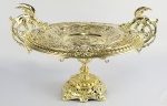 CENTRO DE MESA DE APARATO EM BRONZE. DECORADO COM MEDALHÕES CONTENDO EFIGIE DOS  REIS FRANCESES HENRQUE II, HENRIQUE III, FRANCSICO I  E CHARLES VIII. NA BORDA MEDALHÕES COM CENAS DE QUERUBINS. ALÇAS LATERAIS NA FIGURA DE DRAGÕES. EUROPA, INICIO DO SEC. XX. 39 CM DE DIAMETRO