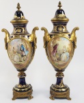 SEVRES - CHATEAU DES TULLERIES  (PERÍODO MARQUES DE TRES RIOS - JOAQUIM EGYDIO DE SOUZA ARANHA) FORMIDÁVEL PAR DE ÂNFORAS  EM PORCELANA DE SEVRES NA TONALIDADE AZUL COBALTO REMATADA EM PROFUSO OURO.. PEGA E BASE EM BRONZE ORMOLU. CONTÉM RESERVAS FRONTAIS COM CENAS DE GALANTEIO , EM UMA DELAS O CAVALHEIRO É APRESENTADO PINTANDO RETRATO DA DAMA E NA OUTRA  UM CASAL EM CONVERSAÇÃO. NA FACE OPOSTA MANSÕES CAMPESTRES EM MEIO A VEGETAÇÃO AS RESERVAS SÃO ASSINADAS G POITEVIN. FRANÇA, SEGUNDA METADE DO SEC. XIX. 49 CM DE ALTURAG. POITEVIN