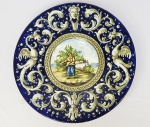 TRADIÇÃO DE DERUTA - LINDO MEDALHÃO EM MAIOLICA COM RICA DECORAÇÃO EM ESMALTE AO GOSTO RENASCENTISTA. POSSUI ANTIGA ETIQUETA DO BAZAR PARISIEN NA RUA DE SÃO BENTO. (VIDE NOS CRÉDITOS EXTRAS DESSE LOTE PROPAGANDA DO BAZAR PARISIEN NA DEC. DE 1910) ITÁLIA, SEC. XIX/XX.  37 CM DE DIAMETRO. NOTA: Originalmente, maiolica ou di maiolica referia-se à cerâmica esmaltada e pintada semelhante à dosmouros da Espanha muçulmana que costumava chegar à Itália através de Maiorca. Foi decorado com motivos orientais, e ficouainda mais rico por um tipo particular de verniz iridescente que mudou do vermelho rubi ao amarelo isabelino e ao verde voador espanhol, das nuances frias e prateadas do metal aostons mais quentes do ouro. Esta decoração foi reproduzida de forma flagrante pelos nossos oleiros e foi feita sobre peças já envernizadas e assadas, que depois foram assadas mais uma vez num forno reverberatório especial . A versão italiana da cerâmica mourisca era também conhecida como di maiolica oumaiolica, mesmo sem a iridescência característica dada pelo terceiro processo de cozimento, que era particularmente comum nos ateliês de Deruta e Gubbio, onde o mestre Giorgio Andreolitrabalharia peças já pintadas. A verdadeira invenção da maiolica italiana foi o uso habilidoso de uma paleta pictórica completa em sua superfície estanífera empoeirada antes da segunda cozedura, logo após o envernizamento do medalhão. É uma mistura de mil ideias e expedientes experientes capazes de criar algo novo, uma evolução que atingiu o seu ápice no início dos anos 500. São invenções absolutas e inimitáveis, segredos que cada ateliê considerou seus, símbolos de um nível de respeitabilidade quasesempre sinônimo de sucesso.