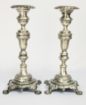 LINDO PAR DE CASTIÇAIS DITOS PÉS DE GARRA. FUSTE COM FEITIO DE BALAUSTRE. BLEOS GUILLHOCHES. BOBECHES REMATADAS EM PALMÁCEAS. BASE FINALIZA EM QUATRO CAPRICHADOS PÉS EM BOLA. BRASIL, MEADOS DO SEC. XIX. 22 CM DE ALTURA. 585 G