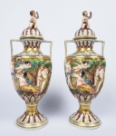 DRESDEN  MAGNIFICO PAR DE ANFORAS EM PORCELANA DECORADO EM RELEVO COM CENAS BACANTES. ARREMATES EM OURO. MARCAS DA MANUFATURA SOB A BASE SITUADA PARA PRIMEIRA DÉCADA DO SEC. XX. TAMPAS COM PEGAS EM FEITIO DE PUCCI. ALEMANHA, CIRCA DE 1902. 29 CM DE ALTURA