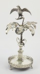 EXUBERANTE PALITEIRO EM PRATA DE LEI. APRESENTA BELO PÁSSARO COM ASAS ABERTAS SOBRE FLROES E RAMAGENS. BRASIL, SEC. XIX. 20 CM DE ALTURA