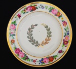 DOM PEDRO I - SERVIÇO DA ILÚSTRISSIMA CÂMARA OU SERVIÇO FUMO E CAFÉ RARO PRATO EM PORCELANA COM ABA DECORADA COM LUXURIANTE GUIRLANDA COM FLORES COLORIDAS. CALDEIRA DE RAMO DE FUMO E CAFÉ UNIDOS POR CAPRICHADO LAÇO. FOI ENCOMENDADO PELA SENADO DA CORTE PARA SER OFERTADO AO IMPERADOR DOM PEDRO I, QUE EM 1823 CONFERIU AO PARLAMENTO CARIOCA A HONRARIA DO TÍTULO DE ILUSTRÍSSIMA CÂMARA MUNICIPAL(VIDE NOS CRÉDITOS EXTRAS DESSE LOTE O ANTIGO PRÉDIO DA ILUSTRISSIMA CÂMARA DO RIO DE JANEIRO NA ÉPOCA DE DOM PEDRO I). O ANÚÁRIO DO MUSEU IMPERIAL BRASILEIRO PUBLICADO EM 1942 TRAZ SOBRE ESSE SERVIÇO, AS SEGUINTES INFORMAÇÕES: Ainda desse tempo um belíssimo serviço, também raro nas nossas coleções. É o que pertenceu a ilustríssima Câmara Municipal do Primeiro Reinado, todo branco, borda em cercadura de flores, ramos de fumo e café ao centro. Pinturas a encarnado e verde, lembrando muito a decoração da fábrica Dagoty, têm eles, entretanto, a marca de De Roche 12. Ao que já ouvi dizer de pessoa informada, esse aparelho foi, quase em vésperas da abdicação, presenteado pelo imperador a uma afilhada de batismo, de família afeiçoada ao paço e moradora no caminho velho de Botafogo 13. Em seguida, dispersou-se pelos leilões e antiquários, alcançando os museus e as mãos ciosas dos felizardos que possuem restos dele. MARCA DO DECORADOR DEROCHE NO VERSO. PEÇA IDÊNTICA INTEGRA O ACERVO DO MUSEU IMPERIAL EM PETRÓPOLIS E ENCONTRA-SE REPRODUZIDO A PÁG. 207 DO LIVRO "LOUÇA DA ARISTOCRACIA NO BRASIL", POR JENNY DREYFUS. INÍCIO DO SÉCULO XIX. 21,5 CM DE DIAMETRO. NOTA: A Câmara Municipal foi desde sempre um órgão prestigiado na administração portuguesa e também na de suas colônias. Era destinada aos cidadãos proeminentes da sociedade. No Rio de Janeiro, sede do Reino Unido nos tempos de Dom João VI e sede da Corte do Império a partir de Dom Pedro I, tão mais importante foi a Câmara do Senado Municipal. Tal foi que em 1823 nas festividade de aniversário do célebre Dia do Fico, o primeiro passo para nossa Independência no ano seguinte, o Imperador achou por bem galardoar a Câmara com o título de ILUSTRÍSSIMA CÂMARA MUNICIPAL DO RIO DE JANEIRO A distinção dos vereadores já se dava com as vestimentas. Havia um traje especial desde as ordenações da restauração de Portugal. No auto de levantamento e juramento do d. João IV, a 1o de dezembro de 1640, lê-se que o presidente da Câmara de Lisboa, conde de Castanhede, compareceu vestido de veludo negro aforrado de tela branca e mangas da mesma cor. No Rio de Janeiro, o traje dos vereadores durante a permanência da corte portuguesa no Brasil e sob o governo de d. Pedro I, até 1828, era composto de casaca, calção e colete pretos, meias brancas e sapatos de fivela. O chapéu de seda preta era desabado e com a frente levantada, guarnecido nas abas de pluma branca; na frente, presilha dourada e laço português. A partir de certa época passaram a usar um penacho de três plumas brancas sobre o laço (Est. 18). A peça mais característica era a capa preta com volta e pala de seda branca bordadas a ouro e prata; jabô de rendas brancas. Empunhavam vara branca e, nos bandos e cortejos desfilavam a cavalo com a montaria ricamente ajaezada, sendo as crinas trançadas com fitas e a cauda enfeitada de laço e de longas fitas de várias cores. O Senado da Câmara tinha sua bandeira e teve diversas. Depois da Independência passou sua insígnia a ser a bandeira imperial em seda adamascada, com franja, e armas bordadas. Tinha como remate a esfera armilar em prata. Sua forma era a de um trapézio retângulo 52. Pela reforma das câmaras municipais, determinada pela lei de 1o de outubro de 1828 seu traje foi abolido. Em 1841, porém, por avisos de 25 de janeiro e 15 de abril, foi declarado que os vereadores do Senado da Câmara do Rio de Janeiro podiam usar de novo as vestiduras antigas com capa de volta nas solenidades, mas não o estandarte e as varas. O decreto no 1.965 de 26 de agosto de 1857 aprovou o uniforme para os vereadores da ilustríssima Câmara Municipal do Rio de Janeiro, conforme modelo anexo reza o decreto. Tal modelo, como os figurinos dos senadores e dutados não foi encontrado. Baseamos a Est. 19 no retrato de Adolfo Bezerra de Meneses e em outros documentos. Como é natural, os uniformes dos vereadores obedeciam às disposições em uso, sendo porém a casaca de cor azul-ferrete. Em grande uniforme, a gola e os canhões eram guarnecidos de galão e de ramos de cafeeiro e tabaco trançados (semelhantes aos dos presidentes de província, mas sem a casa). Era usada aberta, com oito botões, colete e calça de casimira branca, esta, com galão largo; sobre o colete, cinto de pano azul-ferrete com bordados de ramagens e à direita borlas de franja dourada; chapéu armado com presilha de dragão, tope nacional e pluma; espada, luvas e botinas. Em pequeno uniforme, casaca aberta formando lapelas com bordados somente na gola deitada; calça e colete brancos ou azulferrete, chapéu armado sem pluma e o resto conforme o uso. MAS COMO EM NOSSOS DIAS NEM SEMPRE OS ILUSTRES VEREADORES DO RIO DE JANEIRO PORTARAM-SE COM A DIGNADE DO CARGO E FUNÇÃO QUE EXERCEM: A conferência de 28 de abril de 1883 do Conselho de Estado foi convocada para que os seus membros emitissem parecer sobre os graves acontecimentos que se repetiam, com freqüência, na Ilustríssima Câmara Municipal da Corte desde a posse de seus membros, efetuada a 6 de janeiro daquele ano. Segundo os esclarecimentos prestados pelo Ministro de Estado dos Negócios do Império responsável pela administração do Município Neutro quase não se realizavam sessões, por falta de comparecimento da maioria dos vereadores. Além disso gostavam eles o tempo em discussões acaloradas que algumas vezes quase têm chegado a pugilato, tomando parte os expectadores e levantando-se as sessões tumultuariamente. Mesmo com a intervenção da força pública o presidente não conseguia manter a ordem. Nada se resolvia nas reuniões e o maior prejudicando com isso era o Município. Deveria o Conselho sugerir providências destinadas a escolher quais as medidas mais adequados para pôr fim a essa situação. O assunto era bastante delicado, o que levou os conselheiros a examinarem com extrema cautela a matéria. As sugestões apresentadas insistiam, de modo geral, no restabelecimento da autoridade mediante o apelo à intervenção da força material da Polícia e, como último recurso, a suspensão coletiva da Câmara abrindo-se processo para o fim de apurar devidamente a responsabilidade pelos fatos ali ocorridos. Acabou prevalecendo, porém, e foi adotada pelo governo imperial a decisão de suspender a Câmara Municipal, através de Portaria de 30 de novembro de 1883, e convocada a anterior até que se normalizasse a situação. A medida punitiva atingiu uma instituição que datava de 1565, ano da fundação da cidade. Estácio de Sá concedera-lhe, em julho daquele ano, as terras que constituiriam o patrimônio municipal, como era de uso na época. Por alvará de 10 de fevereiro de 1642, pouco tempo depois da restauração da monarquia portuguesa, conseguiria, por concessão real, gozar das mesmas honras e privilégios concedidos à Câmara da cidade do Porto. Quatro meses mais tarde passaria a ostentar o título de Leal, pelo apoio firme dado ao rei D. João IV. Durante a gestão do governador Gomes Freire de Andrada no Rio de Janeiro, recebeu, em 11 de março de 1748, o privilégio de poder denominar-se Senado. Outras regalias lhe seriam atribuídas mais tarde, como o tratamento de Senhoria (6 de fevereiro de 1818) e o de Ilustríssima, honra esta que lhe foi concedida pelo Imperador D. Pedro l, ao comemorar-se, a 9 de janeiro de 1823, o primeiro aniversário da jornada do Fico. Nos acontecimentos relacionados com o movimento da Independência, em 1821 e 1822 desempenhou ela importante papel, embora tivesse à sua frente um português, José Clemente Pereira. Por lei de 1º de outubro de 1828 passou por importante reforma tendo sido aumentado o número de vereadores. Nesse mesmo ano instalara-se, provisoriamente, em uma de suas dependências, o Supremo Tribunal de Justiça, órgão máximo do Poder Judiciário durante o Império. A Ilustríssima Câmara Municipal estava localizada, na época em que ocorreram as irregularidades levadas ao conhecimento do Conselho de Estado, em imóvel situado entre as ruas General Câmara e São Pedro. O prédio fora inaugurado a 2 de dezembro de 1882, em substituição ao antigo, situado no mesmo local. Os vereadores eleitos em 1883 haviam escolhido para as funções de presidente a João Pedro de Miranda. Com a suspensão decretada pelo governo convocou-se a Câmara anterior, cuja presidência tinha sido exercida pelo Dr. José Ferreira Nobre. A Câmara possuía comissões de Fazenda, de Justiça, de Obras, de Saúde, de Instrução, de Matadouro e de Redação, além dos serviços auxiliares que compreendiam Secretaria, Contadoria, Tesouraria, Diretoria das Obras Municipais, Tombamento e Aferição. Vinculavam-se, ainda, a ela, a Biblioteca Municipal, Empresa de Limpeza da Cidade, Empresa Municipal de Limpeza das Chaminés e as Escolas Municipais.