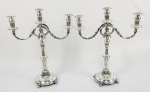 PAR DE CANDELABROS EM PRATA DE LEI COM FEITIO DITOS SERPENTINA. MARCAS DE CONTRASTE PARA PORTUGAL, PRINCIPIO DO SEC. XX. REVERSÍVEIS PARA CASTIÇAIS DE BANQUETE. DOTADOS DE TRÊS LUMES. CORPO COM GOMADOS E ELEGANTES CINZLEADOS EM GUIRLANDA. PÉS EM SAPATA FINALIZADOS EM PEROLADOS. PORTUGAL, 43 CM DE ALTURA . 2400 G