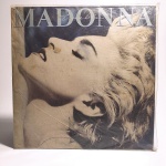 Vinil Madonna: True Blue. Produto Original. Gravadora Sire. Fabricado e distribuído por RCA Eletrônica Ltda. Capa (escurecida, com pontos de oxidação e desgastes do material)/contracapa (com pontos de oxidação, escurecida e com desgastes do material) em regular estado de conservação, manchas/pontos de oxidação, marcação do disco, com sinais de uso, manuseio e desgastes. Disco com riscos, mesmo que superficiais, podem ocasionar algum nível de ruído na audição. Contém encarte, com oxidações. Selo fonográfico com oxidações. Lado A 4 faixas. Lado B 5 faixas.