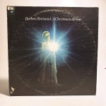 Vinil Barbra Streisand / A Christmas Album. Produto Original. Gravadora Columbia. Fabricado e distribuído por Columbia. Capa (escurecida, com pontos de oxidação e desgastes do material, com abertura em uma borda)/contracapa (com pontos de oxidação, escurecida e com desgastes do material) em regular estado de conservação, manchas/pontos de oxidação, marcação do disco, com sinais de uso, manuseio e desgastes. Contém plástico de proteção do disco. Disco com riscos, mesmo que superficiais, podem ocasionar algum nível de ruído na audição. Não contém encarte. Lado A 6 faixas. Lado B 5 faixas.